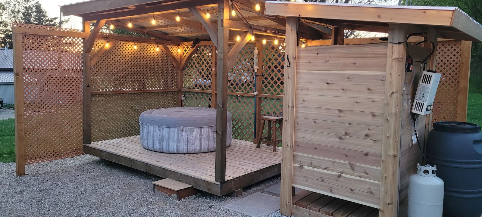 Hot tub area and outdoor shower at Grey County cabin rental